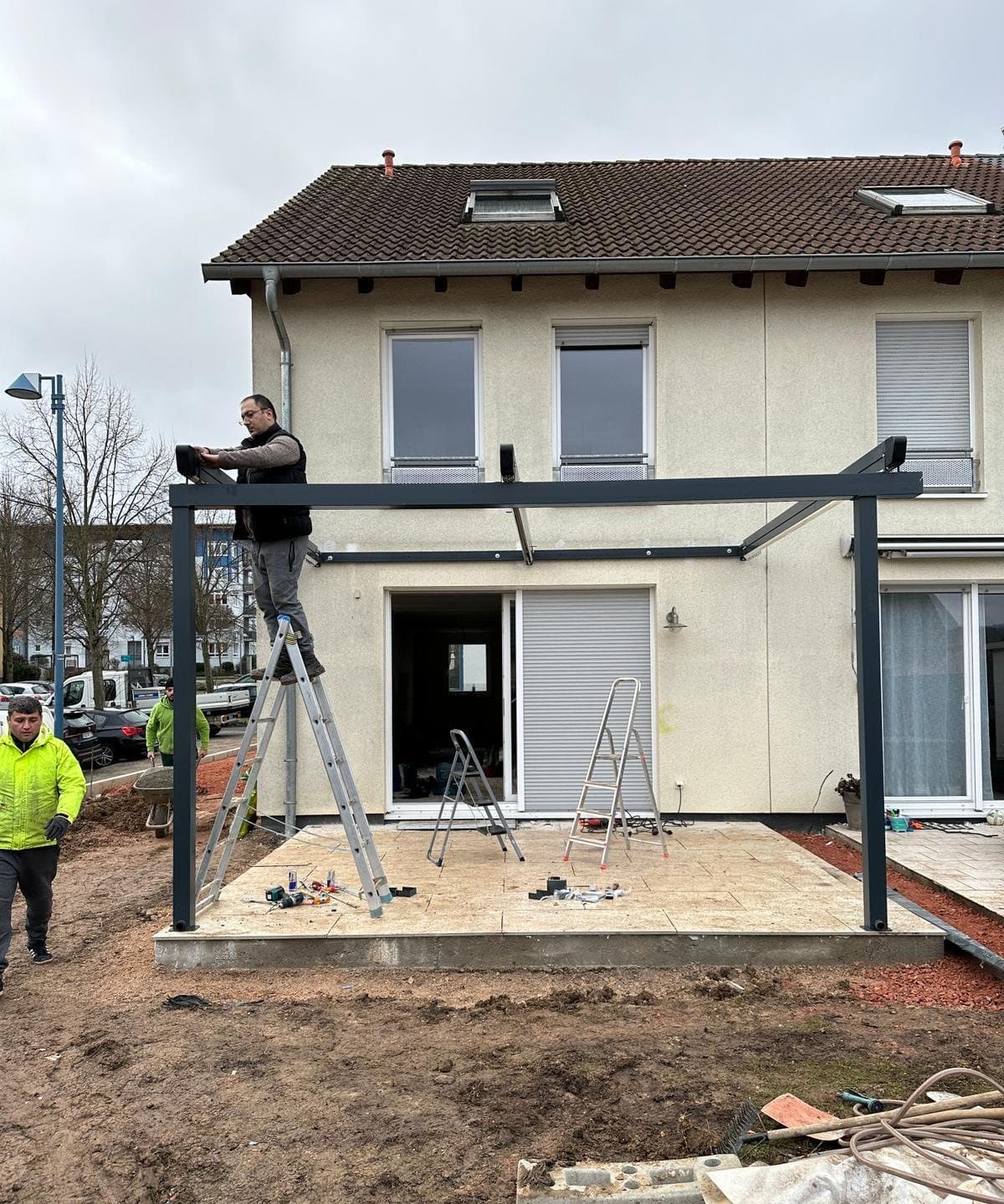 Monteur setzt den Träger des Terrassendachs