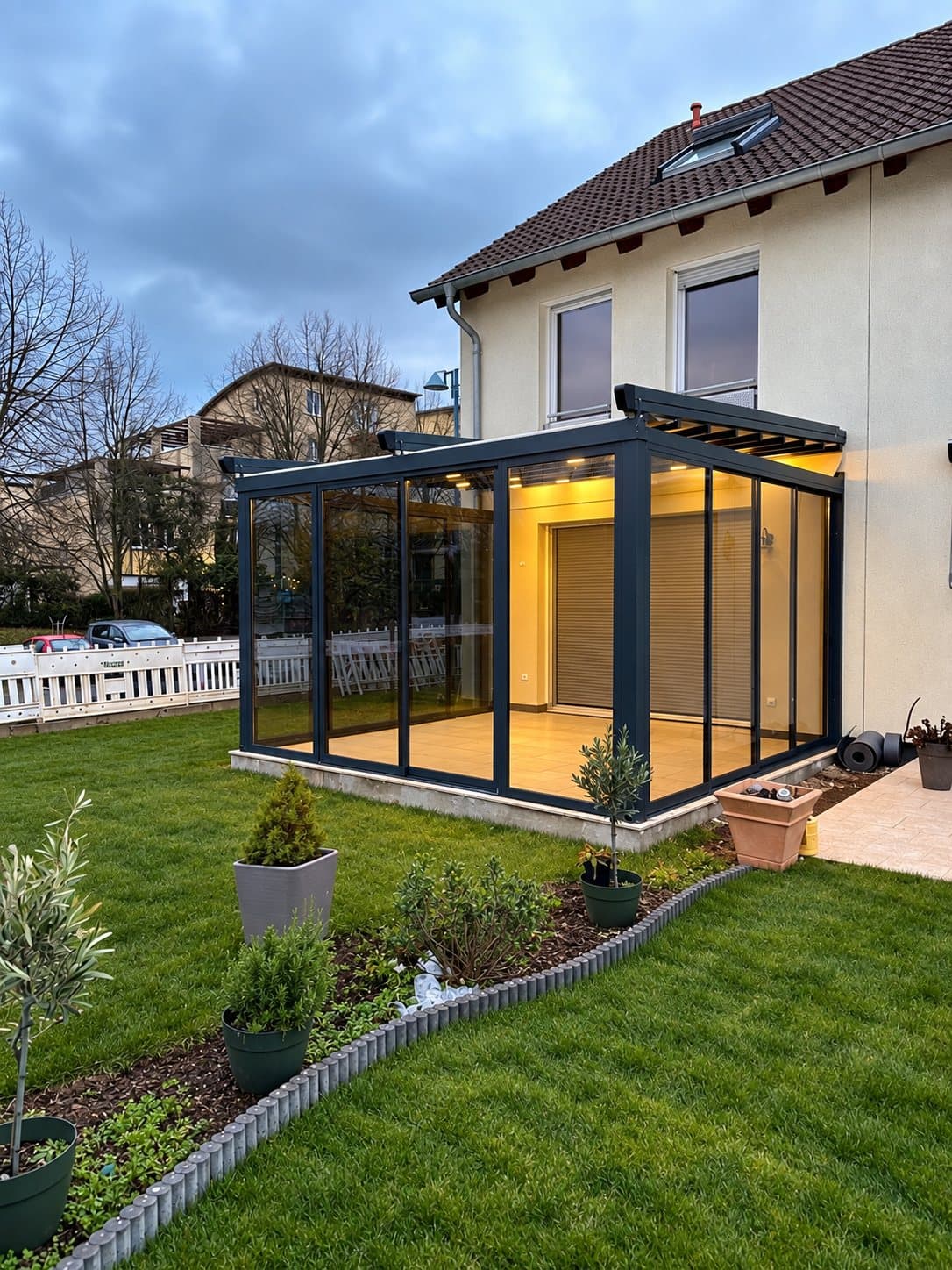 Nachher: verglaste Terrasse mit Glasschiebewänden am Abend